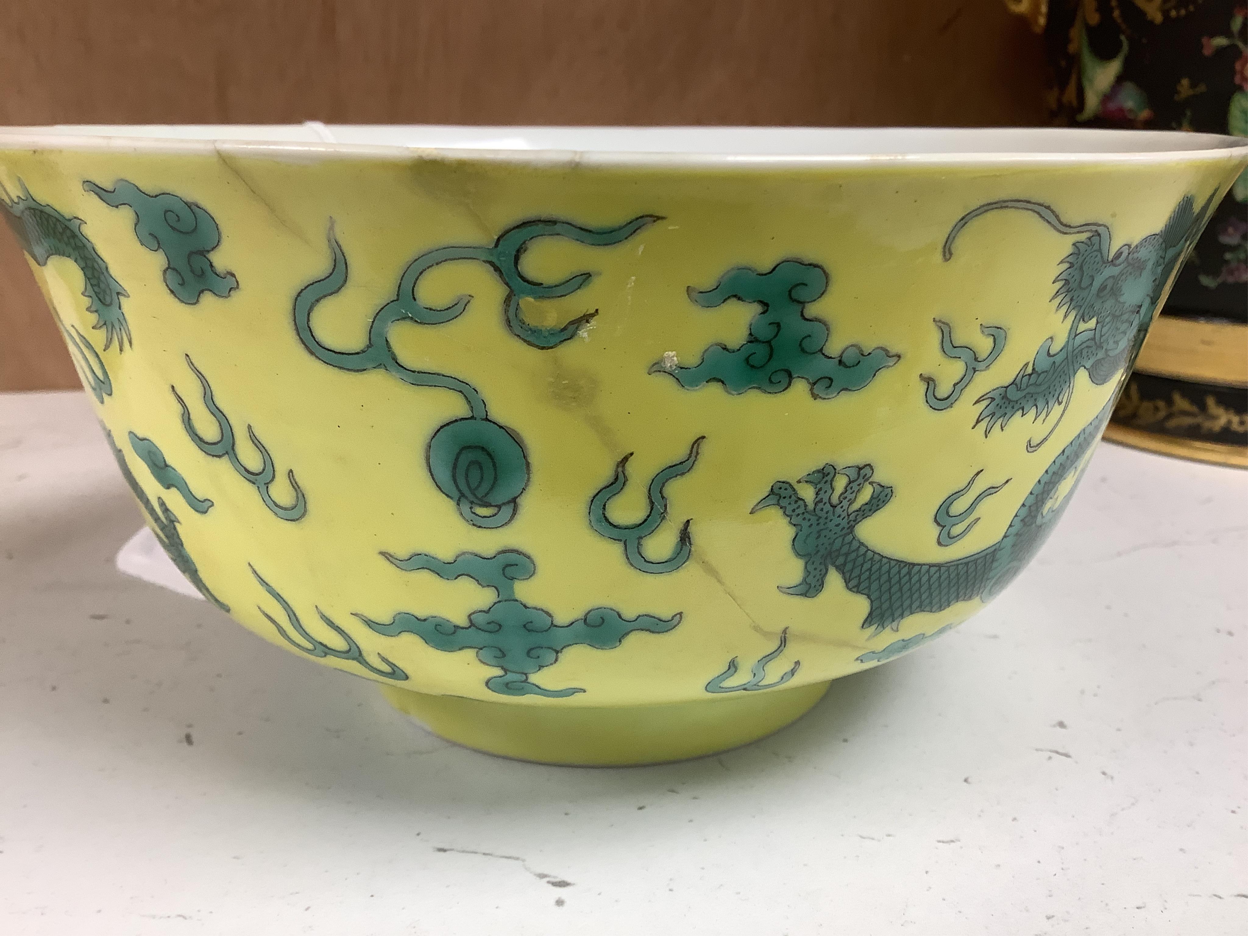 A Chinese yellow ground 'dragon' bowl, probably late Qing dynasty, and a similar floral cup, bowl 9cm high, 18.5cm diameter. Condition - bowl has a large section restored